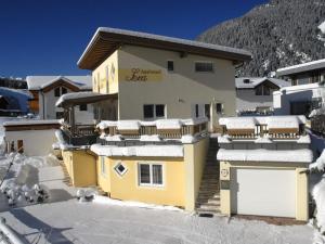 a yellow house with snow on the roof at Holiday Apartment, Apartment Melanie in Niederthai