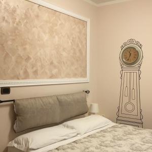 1 dormitorio con 1 cama y reloj en la pared en Hotel Martin, en Volpiano