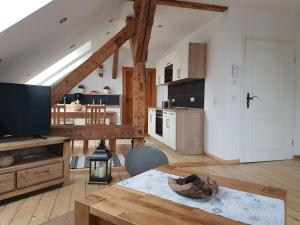 ein Wohnzimmer mit Tisch und Küche in der Unterkunft Stiftsblick Comfortable holiday residence in Gernrode