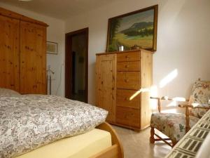 a bedroom with a dresser and a bed and a chair at Wiete Lenk Comfortable holiday residence in Dresden