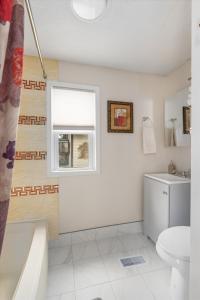 a bathroom with a toilet and a window at Snapdragon Apt - Charming Two Bedroom in Corcoran Neighborhood in Minneapolis