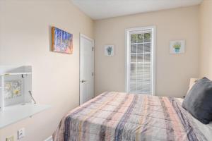 a white bedroom with a bed and a window at Snapdragon Apt - Charming Two Bedroom in Corcoran Neighborhood in Minneapolis