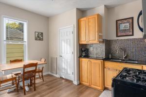 a kitchen with wooden cabinets and a table and a dining room at Snapdragon Apt - Charming Two Bedroom in Corcoran Neighborhood in Minneapolis