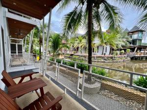 a balcony with a view of a river and palm trees at Airis Sanctuary Resort in Pantai Cenang