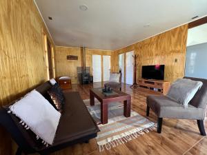 un soggiorno con un divano e una TV di Cabaña en Malalcahuello a Malalcahuello