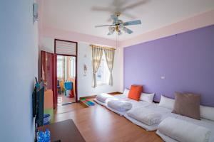 sala de estar con sofá blanco y ventilador de techo en Hualien Travel en Dahan