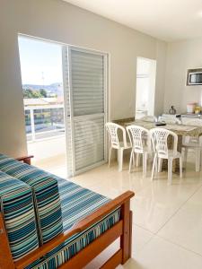 a bedroom with a table and chairs and a balcony at Pousada Gomes in Florianópolis