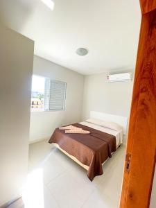 a bedroom with a bed in a white room at Pousada Gomes in Florianópolis