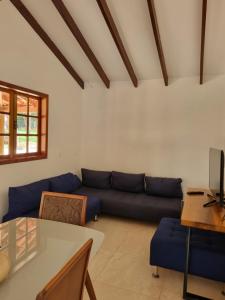 a living room with a blue couch and a table at Sítio Quinta da mata - Casa Amarela in Pirenópolis