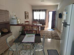 a kitchen with a table and chairs and a refrigerator at Casa agradável e confortável, com piscina in Bonito