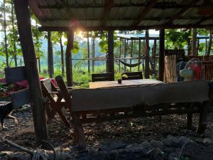 a bedroom with a bed and a table and chairs at Doendin Mudbrick hostel in Ban Phaem Klang