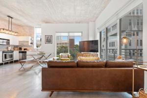a living room with a brown couch and a kitchen at City Loft - Downtown Bayfront pool gym & parking in Miami +39 photos