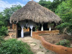 a hut with a thatched roof and a bench at El Nido in Brisas de Zicatela