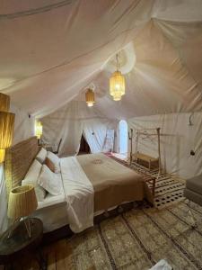 - une chambre avec un lit dans une tente dans l'établissement Mhamid luxury camp, à M'Hamid El Ghizlane