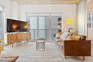 a living room with a couch and a flat screen tv at City Loft - Downtown Bayfront pool gym & parking in Miami