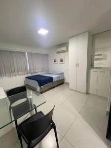 a bedroom with a bed and a table and chairs at Flat Prime BC Ilha do Leite in Recife