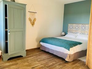 una camera da letto con un letto con una parete blu di Chambre cosy avec salle d'eau, accès piscine chauffée et Wi-Fi illimité - FR-1-591-620 a Faverolles