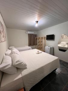 a bedroom with two beds and a television in it at Martuno house in Fernando de Noronha