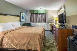 a hotel room with a bed and a television at Roosevelt Hotel in Williston