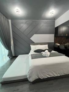 a bedroom with a large bed with two towels on it at SAMSARA Studio Apartment at Kompleks Mutiara GM in Gua Musang +11 photos