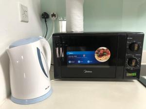 a white blender and a microwave on a counter at Meridin Bayvue - Bayvue Homestay Pasir Gudang in Kampong Kuala Masai
