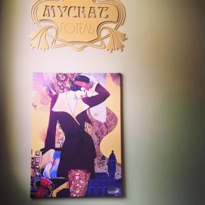 a picture of a woman in a dress on a wall at Hotel Muskat in Kherson