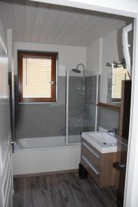 La salle de bains est pourvue d'une baignoire, d'une douche et d'un lavabo. dans l'établissement Gîte Chevênes, à Annecy