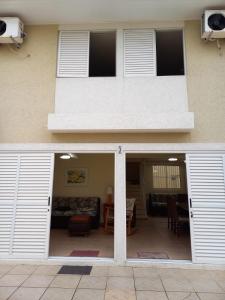 a building with white doors and a balcony at Sobrado 3 Brejatuba in Guaratuba