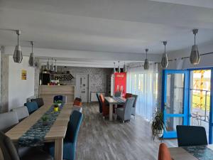 a dining room and living room with a table and chairs at Pensiunea Aventurin in Murighiol