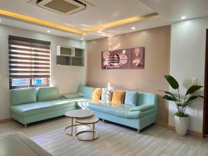 a living room with a blue couch and a table at Cat Ba Seoul 2 Hotel & Apartment in Cat Ba
