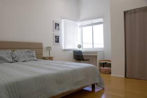 una camera da letto bianca con un letto e una finestra di Mountain View Oasis a Los Angeles