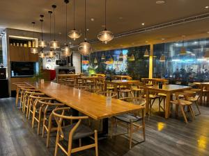 a restaurant with a large wooden table and chairs at The Carlton Hotel Hsinchu in Hsinchu City