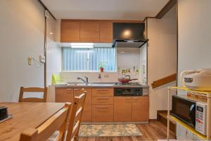 a kitchen with wooden cabinets and a table and a sink at Near Osaka Castle entire villa at Kyobashi Station in Osaka