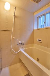 a bathroom with a bath tub and a shower at Near Osaka Castle entire villa at Kyobashi Station in Osaka