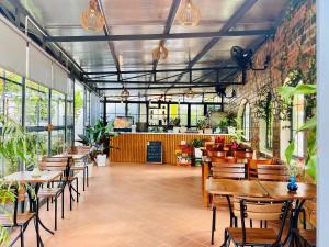 a restaurant with wooden tables and chairs and plants at PaPa Coffee & Homestay in Xã Tân Phát +64 photos