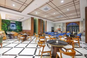 a restaurant with tables and chairs and a green wall at IB23 Inn Boutique Hotel in Bandung