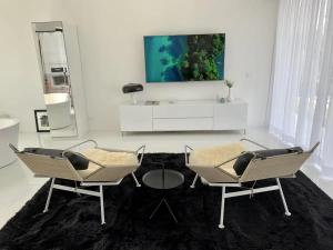 a living room with two chairs and a tv at White Lagoon in Hua Hin
