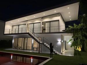 a woman standing in front of a house at night at White Lagoon in Hua Hin
