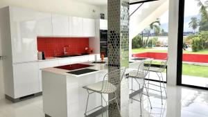 a kitchen with white cabinets and a counter with stools at White Lagoon in Hua Hin