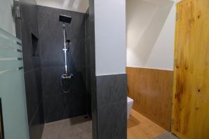 a bathroom with a shower with a toilet at Willing Resort, Trongsa in Kagha +63 photos