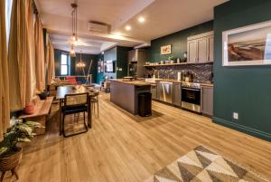eine große Küche mit grünen Wänden und Holzböden in der Unterkunft North House - Majestic 3-Bedroom Designer Apartment in Québec