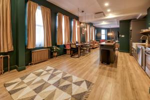 eine Küche und ein Wohnzimmer mit grünen Wänden und Holzböden in der Unterkunft North House - Majestic 3-Bedroom Designer Apartment in Québec