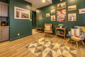 ein Wohnzimmer mit grünen Wänden und Stühlen und einem Teppich in der Unterkunft North House - Majestic 3-Bedroom Designer Apartment in Québec