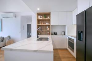 Cucina o angolo cottura di Starlit Palms - Chic Poolside Haven by the Beach