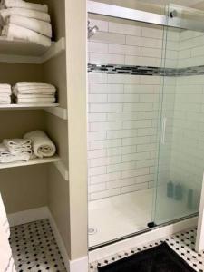 a bathroom with a glass shower with towels on shelves at The Suite at Pound Ridge in Pound Ridge