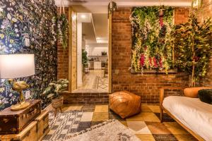 een woonkamer met een bakstenen muur met planten bij North House - Bohemian Vieux Quebec Two Bedroom in Québec