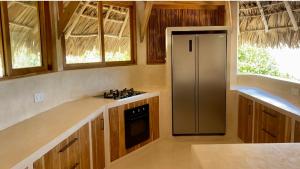 a kitchen with a stove and a refrigerator at Rote Island Lodge in Nembrala