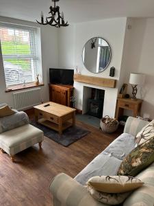 a living room with a couch and a table and a mirror at Cosy Bay Cottage in Scarborough