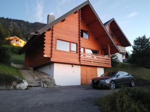 une maison avec une voiture garée devant dans l'établissement Chalet les Alpages vue panoramique sur le lac Léman, à Thollon-les-Mémises