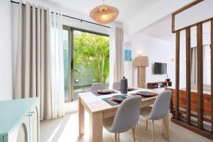 Green Nest Peyrebère في بيريبير: غرفة طعام بها طاولة وكراسي ونافذة